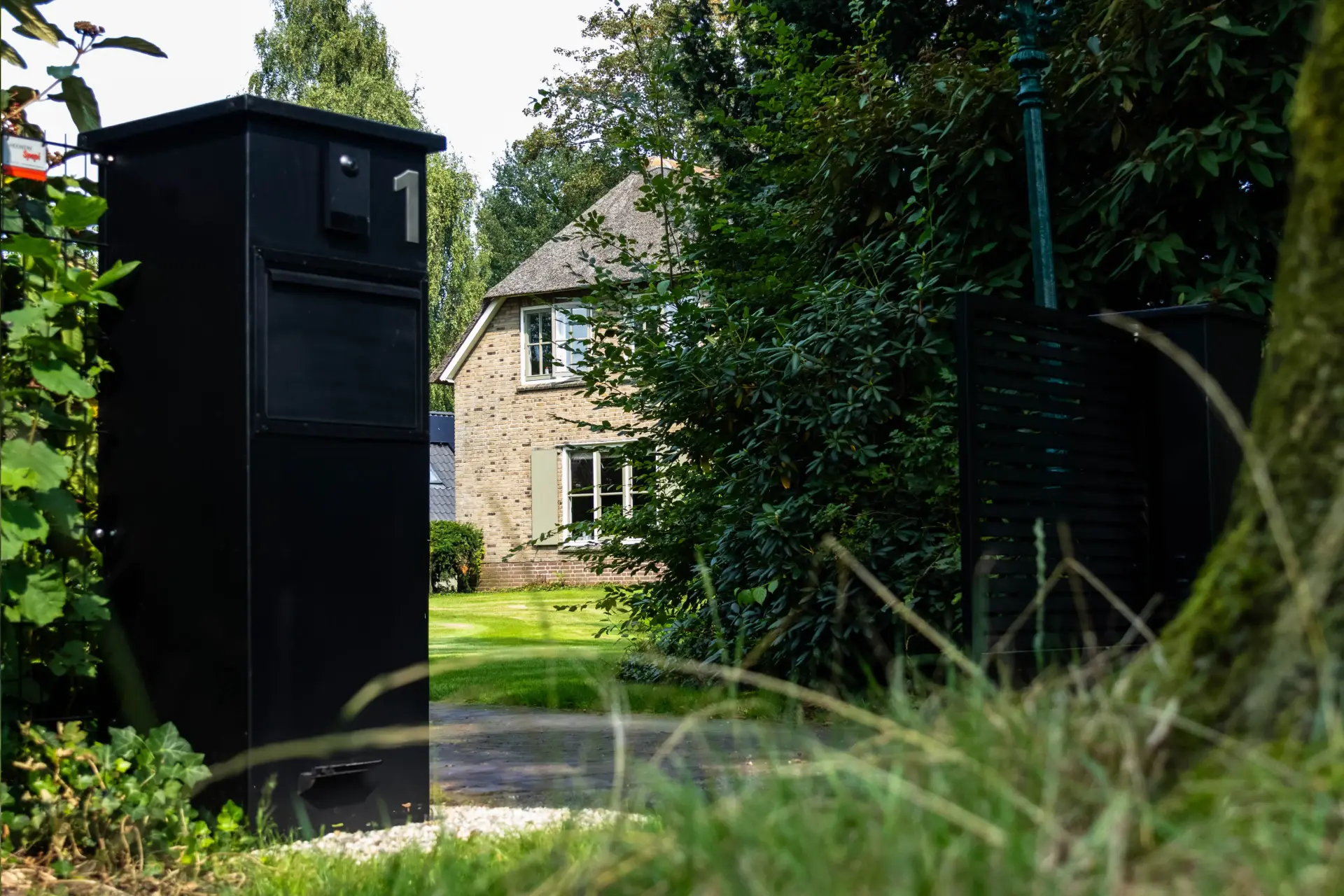 Zwarte geautomatiseerde toegangspoort bij een woning